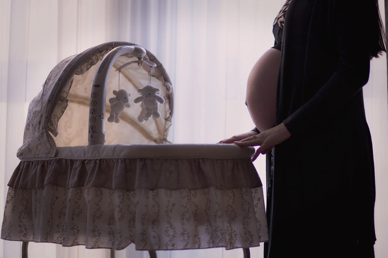 Parent beside a bassinet